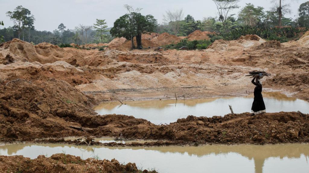 Un agricultor camina a través de una sección de una plantación de cacao destruida por actividades ilegales de extracción de oro en la comunidad de Samreboi, en Ghana.