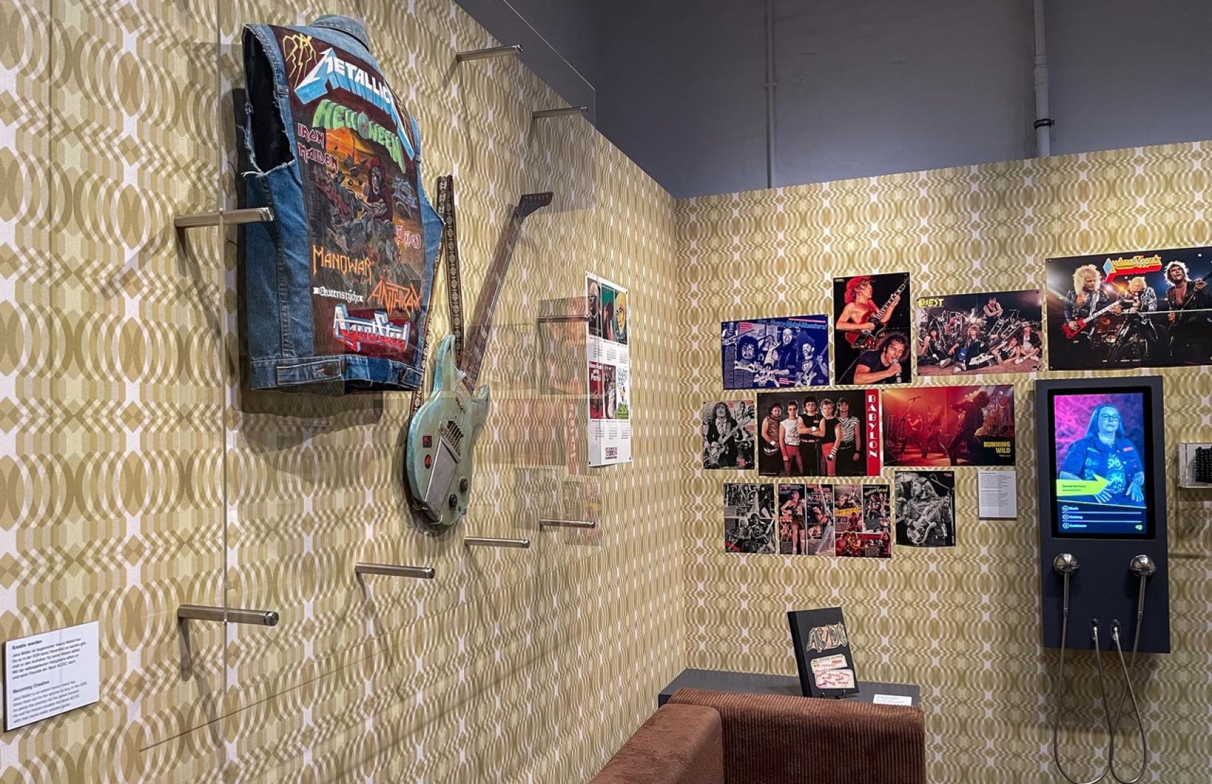 FVista de la exposición con una chaqueta vaquera decorada a mano con motivos heavies y una guitarra eléctrica de fabricación casera. Foto: Stiftung Haus der Geschichte / Thomas Köhler