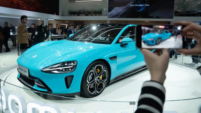 Una persona con un móvil en la presentación del coche Xiaomi SU7 en Barcelona.