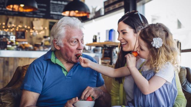 Imagen de una familia comiendo fresas