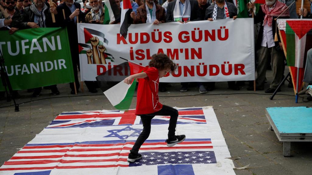 Un niño pisa las banderas nacionales de EEUU, Reino Unido e Israel en una manifestación en Estambul.