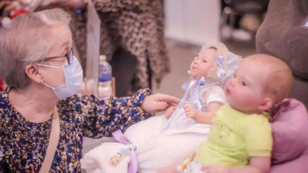 Una persona mayor mirando uno de los 'bebés reborn' expuestos en la feria Daris de 2021.
