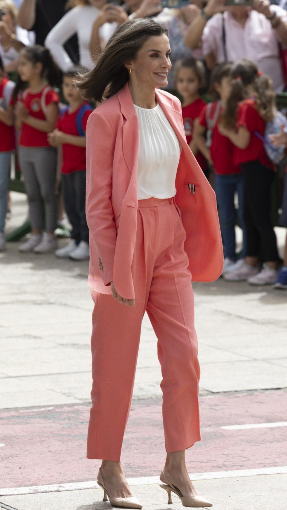 La Reina ha apostado por blusa blanca y zapatos nude.
