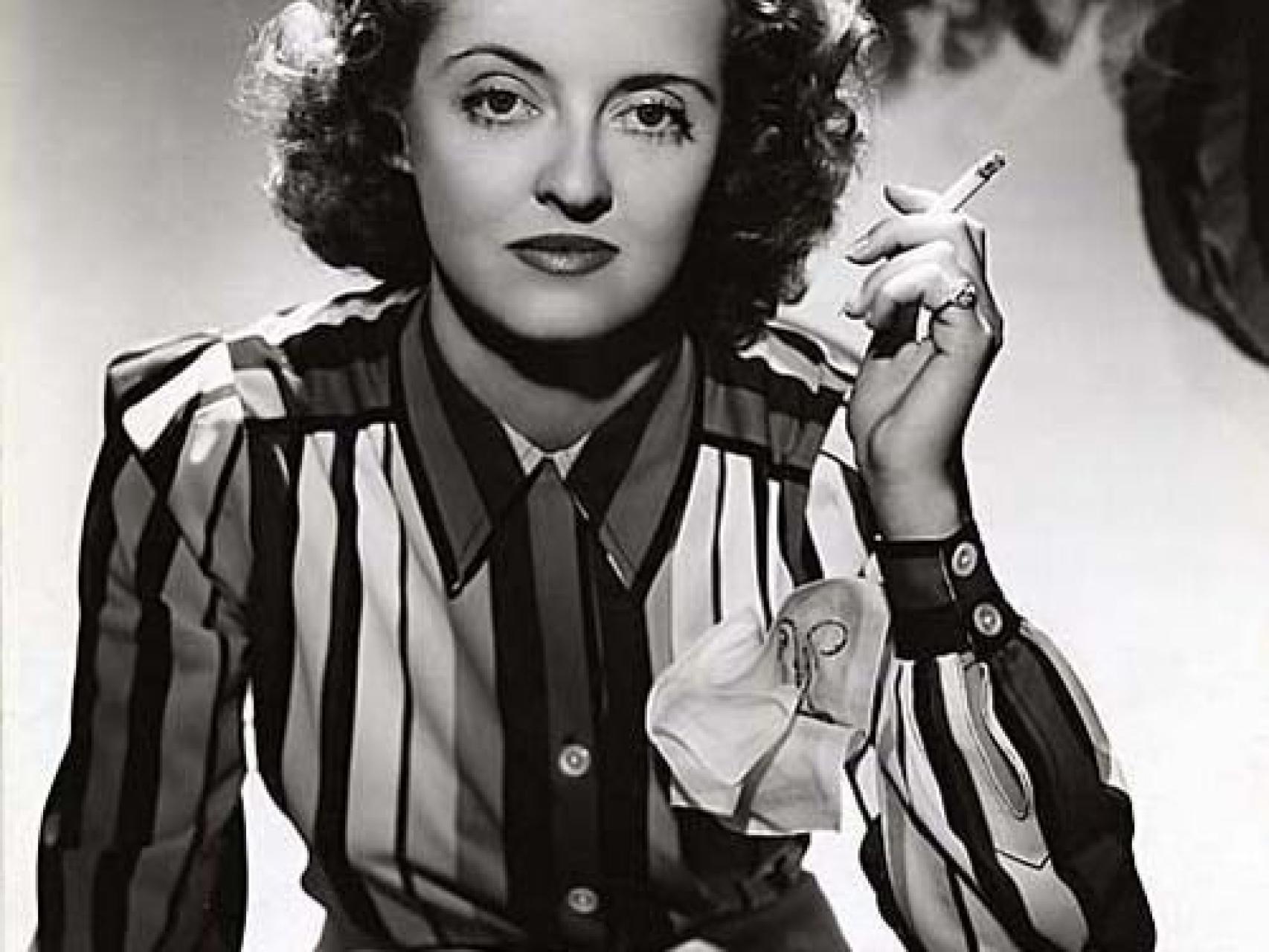 Bette Davis fumando un cigarro.