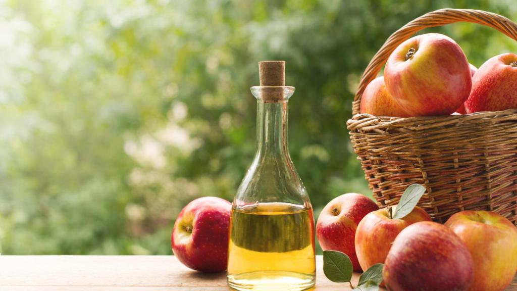 Vinagre de sidra de manzana junto a este fruto.