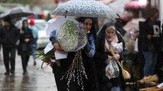 Mujeres iraníes caminan bajo la lluvia en un mercado de flores en Teherán.