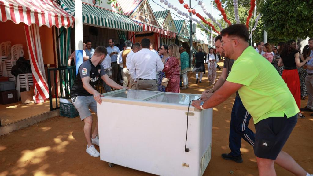 Operarios transportan una cámara frigorífica en las horas previas al estreno de la Feria 2024.