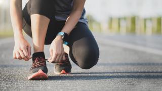 Mujer atándose los cordones de las zapatillas de deporte.