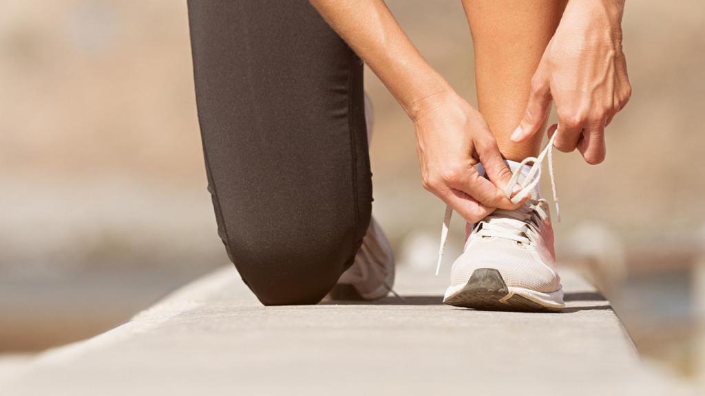 Una persona se ata los cordones antes de hacer ejercicio físico