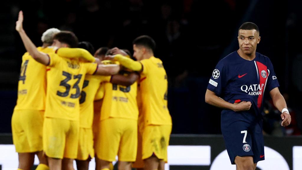 Kylian Mbappé y, de fondo, celebran un gol los jugadores del FC Barcelona