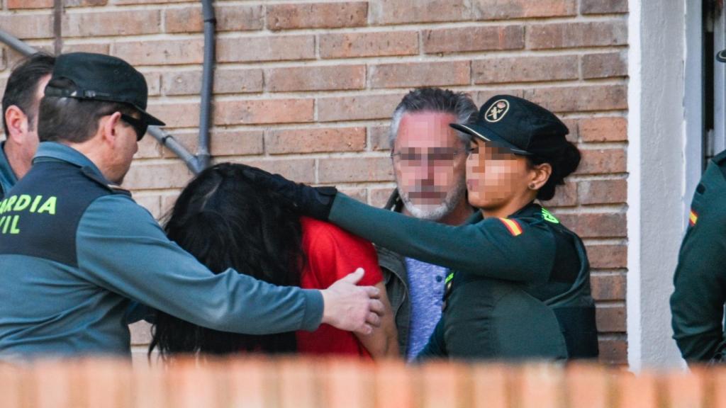 Una guardia civil escolta a la mujer venezolana a la salida de la comandancia.