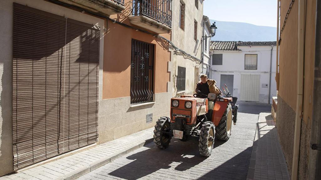 Uno de los habitantes de Benillup junto con su tractor y su perro.