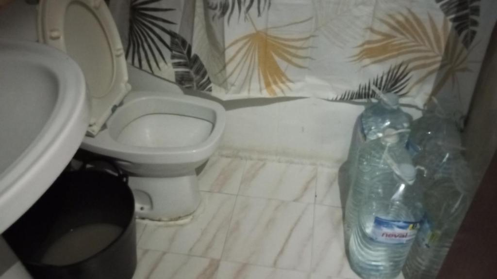 El aseo sin luz y con garrafas de agua en una de las infraviviendas donde residen estos ciudadanos marroquíes.