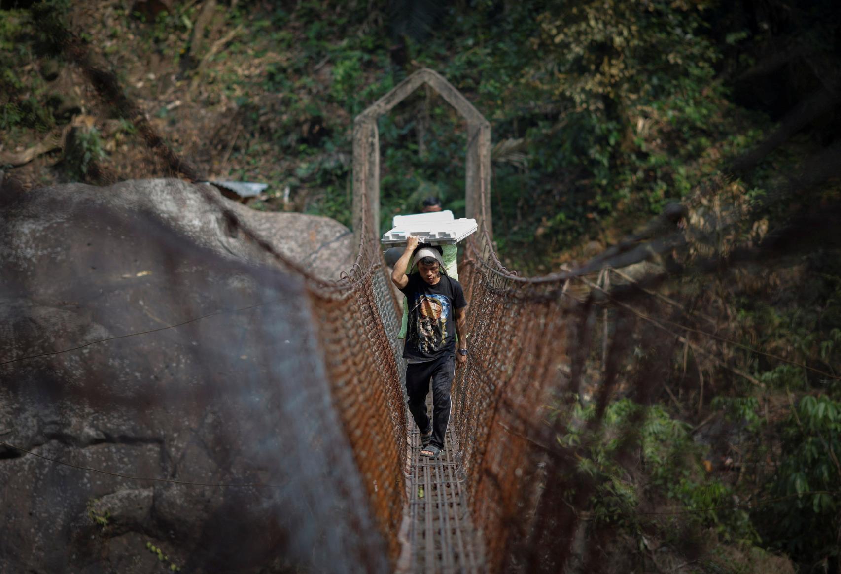 Funcionarios electorales y porteadores transportan máquinas de voto  a una aldea remota de Shillong, al este del país.