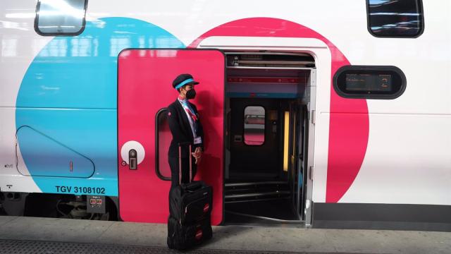 Una empleada espera en la puerta de un tren de Ouigo.