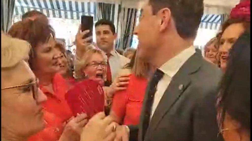 Juanma Moreno, con las señoras que le piropearon en la caseta de CCOO.