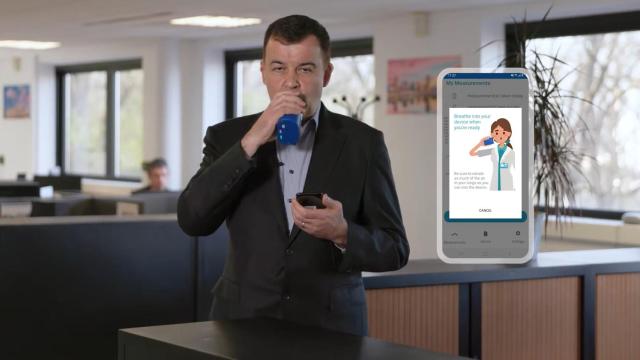 Una persona usando el dispositivo BOYDSense para medir la diabetes con el aliento.