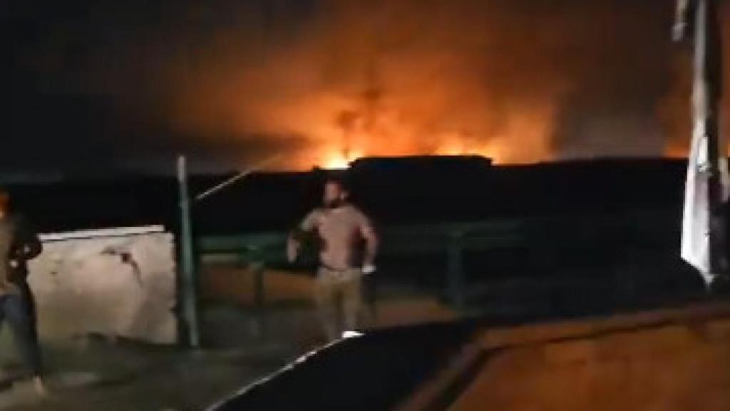 Un soldado iraquí hace señas al camión de bomberos para dirigirlo hacia el incendio en la base militar.