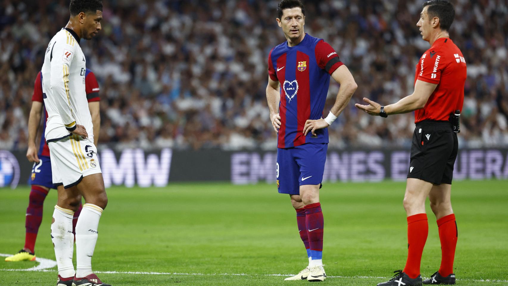 El colegiado Soto Grado junto a Lewandowski y Bellingham durante la revisión del VAR