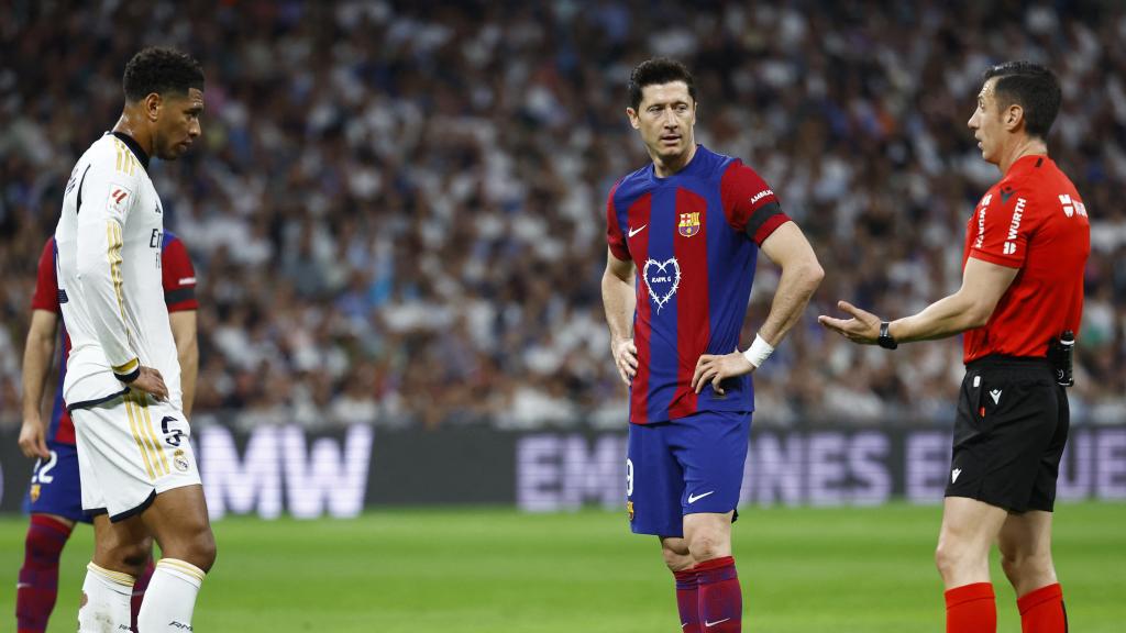 El colegiado Soto Grado junto a Lewandowski y Bellingham durante la revisión del VAR