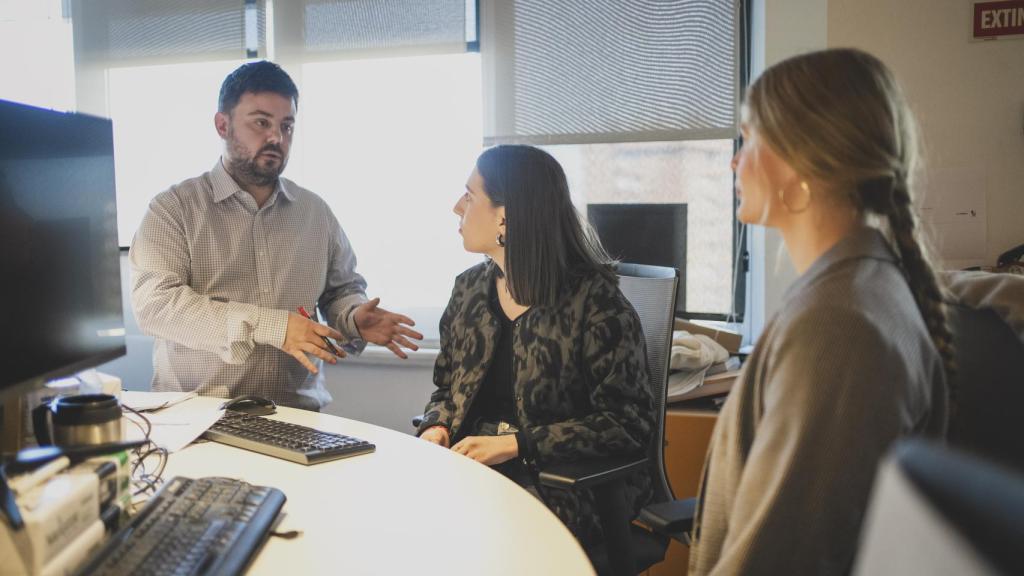 Dos alumnas de la primera edición del Máster reciben indicaciones de Arturo Criado, subdirector de Invertia.