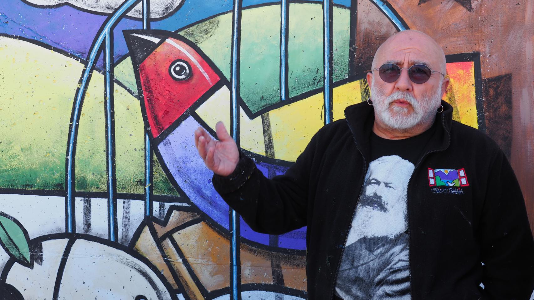 El pintor Manuel Sierra junto a su mural del municipio vallisoletano de San Pelayo.