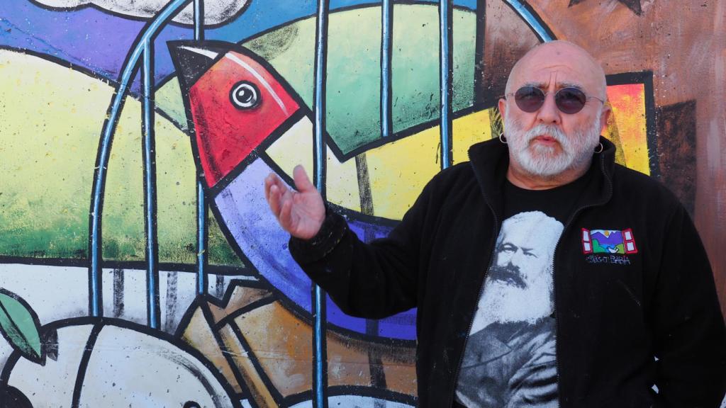 El pintor Manuel Sierra junto a su mural del municipio vallisoletano de San Pelayo.