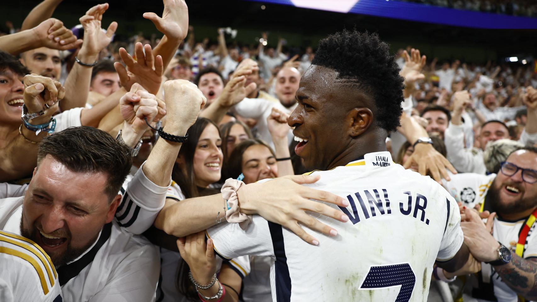 Vinicius se abraza con los aficionados del Real Madrid.