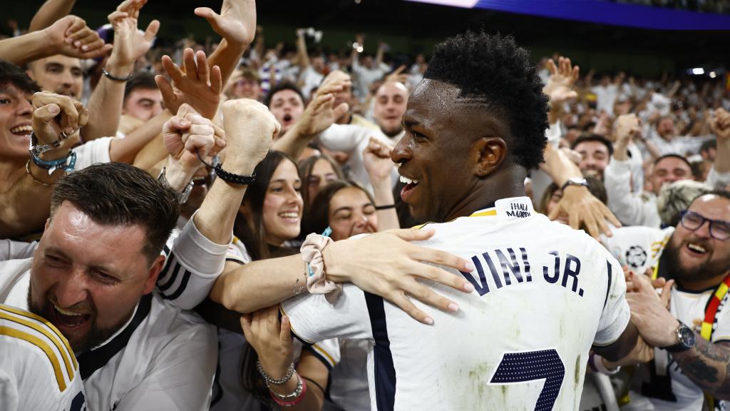 Vinicius se abraza con los aficionados del Real Madrid.