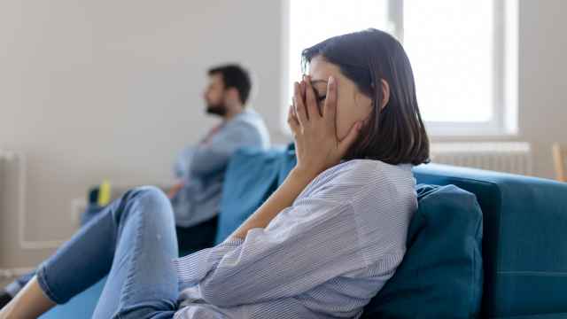 Mujer triste tapándose la cara con las manos.