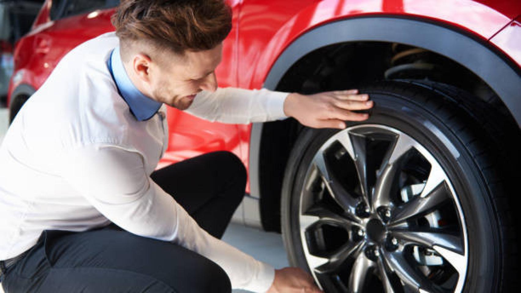 Un hombre limpiando las llantas de su coche