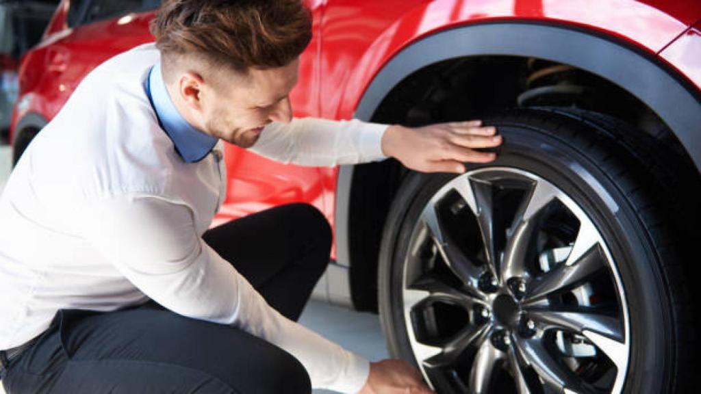 Un hombre limpiando las llantas de su coche