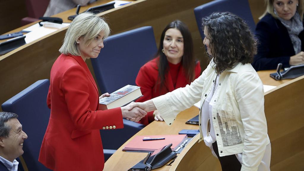 La socialista Mercedes Caballero entrega un libro a Elisa Núñez