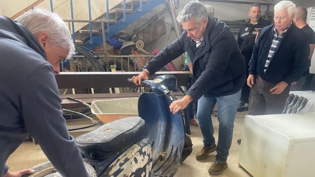 La familia ayuda a Chato a sacar la moto.