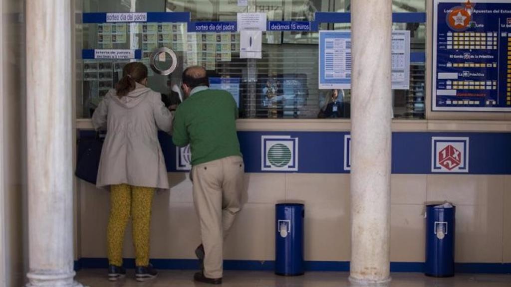 Imagen de archivo de dos personas en una administración de loterías.