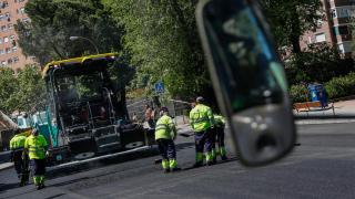 Operarios durante los trabajos de reasfaltado en una calle de Madrid.