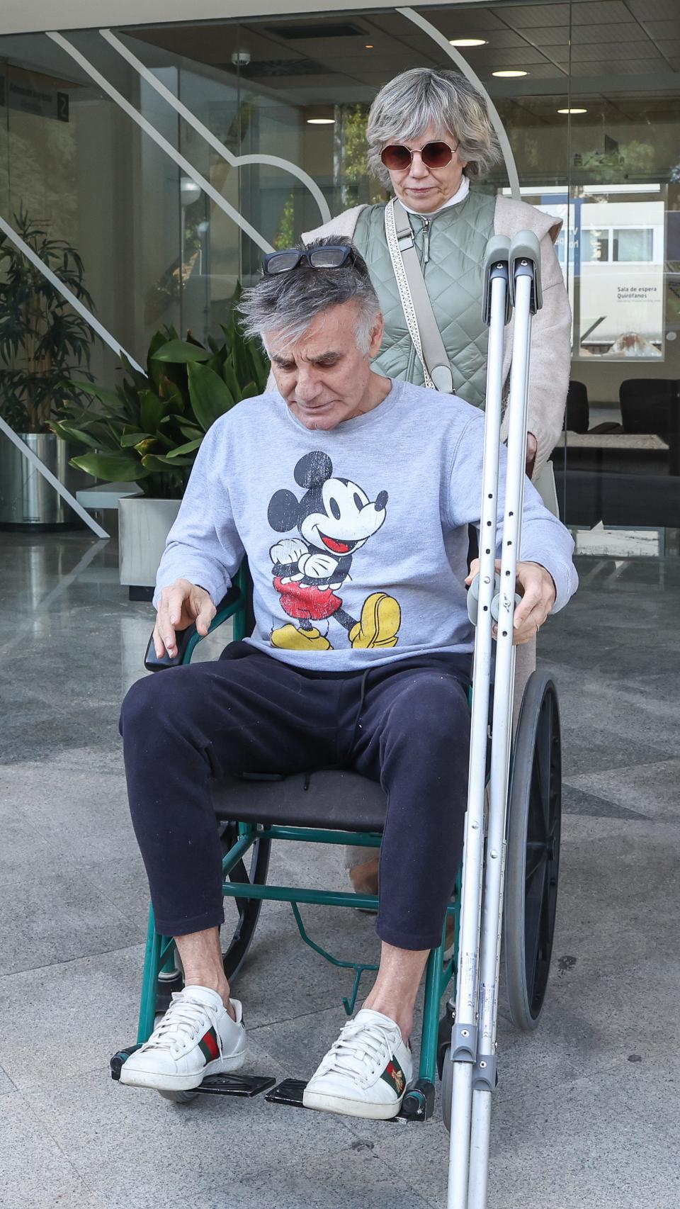 Joaquín Torres, saliendo del centro médico, ayudado por una amiga.