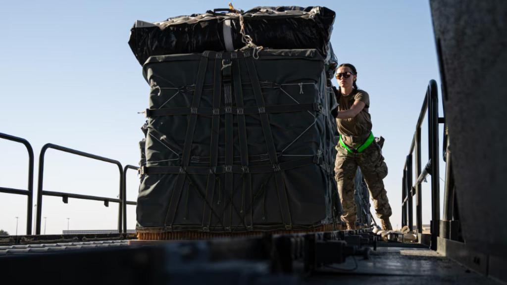 Una militar estadounidense carga ayuda humanitaria en un avión de transporte.