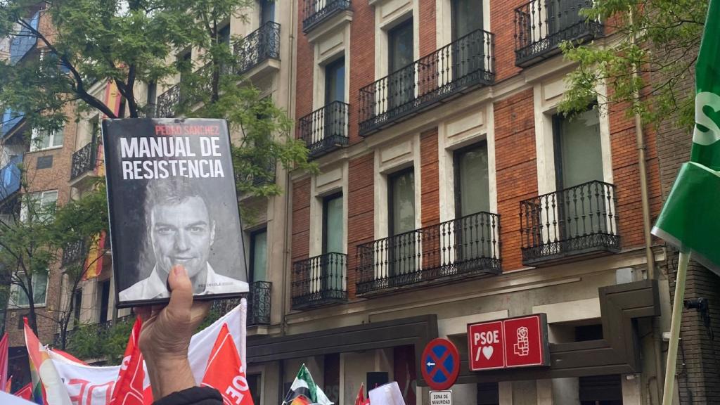 Juan, durante la concentración en Ferraz, sosteniendo el libro de memorias de Sánchez.