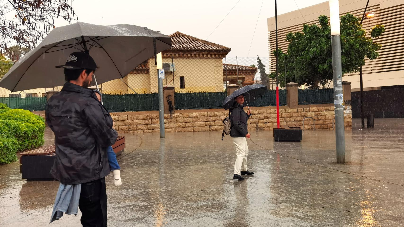 Una pareja cruza una plaza en Alicante.