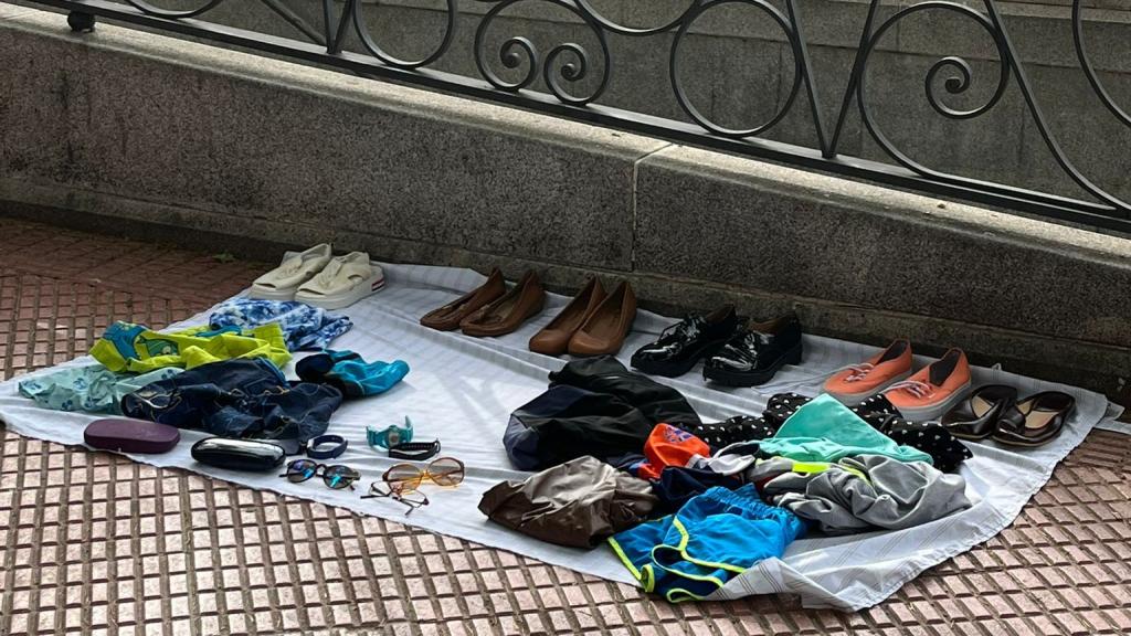 Un hombre vende junto al metro varios objetos.
