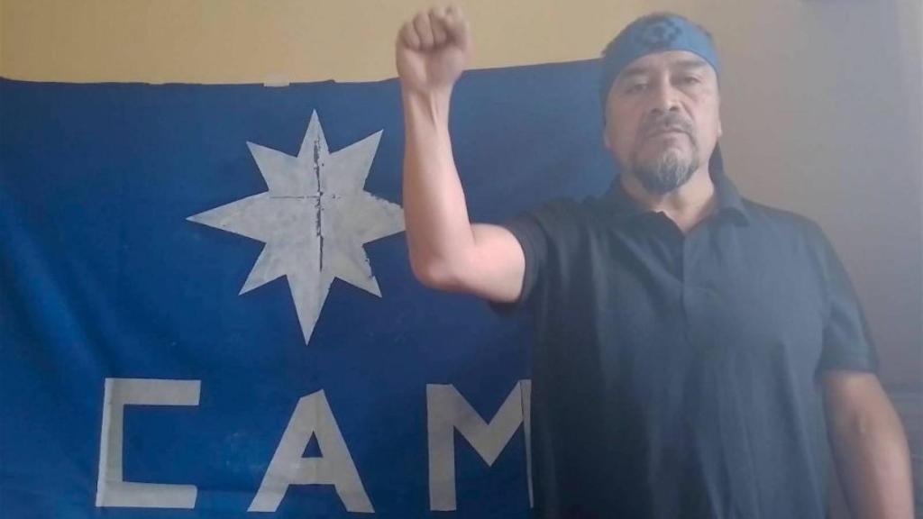 Llaitul posa con el puño erguido delante de una bandera de la CAM.