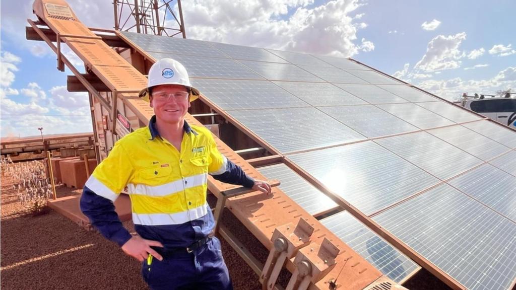 Uno de los operarios de la mina junto al robot ASCR y los paneles solares
