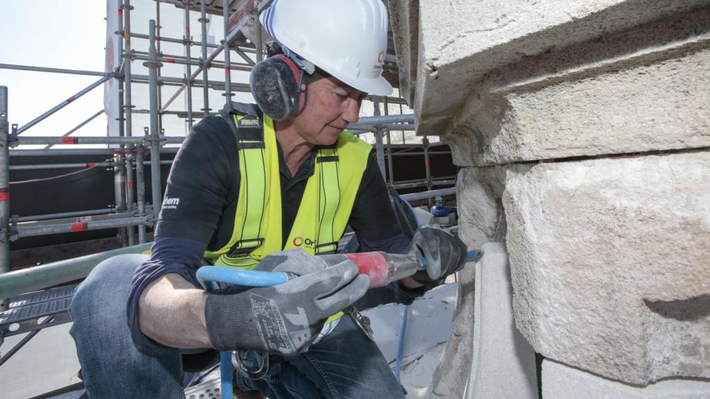 María Reyes Molina da forma con un cincel a una pieza de los jarrones de la parte superior de la Catedral de Murcia.