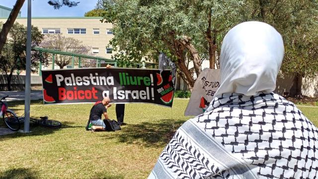 Una estudiante, frente a una pancarta reivindicativa.