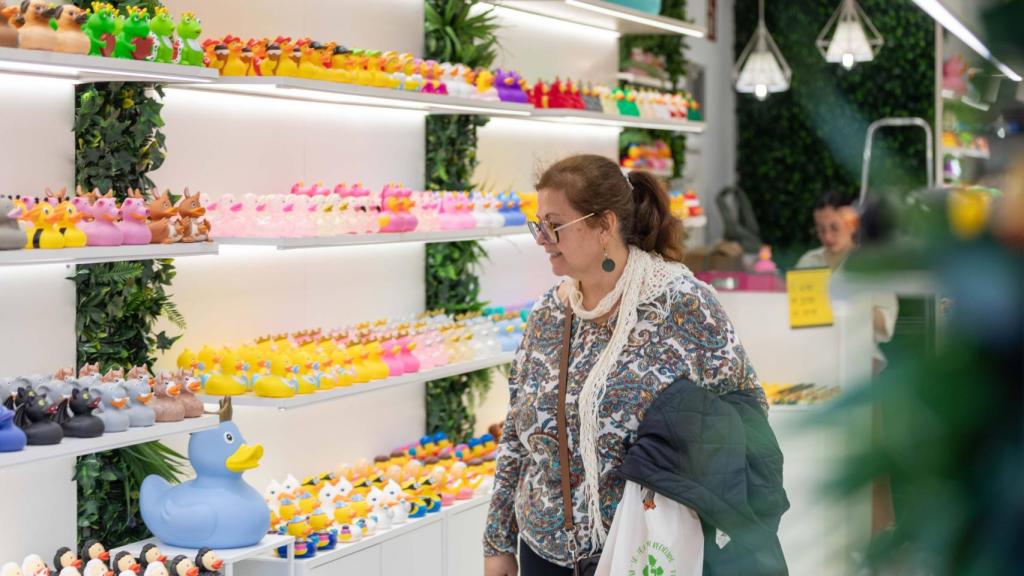 Una mujer observa los patitos de goma en el interior de la tienda.