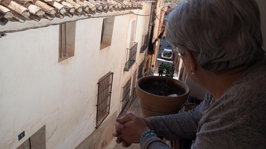 Maricarmen, este jueves, contemplando desde su ventana a los guardias civiles que custodiaban la casa de su difunta amiga, Alicia.