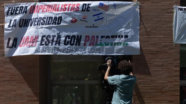 Un estudiante pone una pancarta en la UCM durante una acampada para mostrar su apoyo al pueblo palestino.