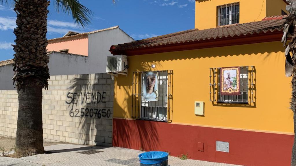 Un solar en venta en Burguillos,  junto a una vivienda con las imágenes de una Virgen y un Cristo.