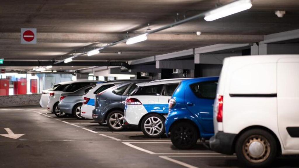 Varios coches aparcados en una plaza de garaje.